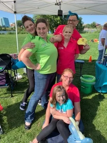 Just 4 Laffs team members at an outdoor community event with balloon creations